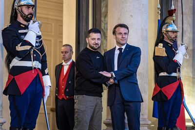 French President Emmanuel Macron gives Volodymyr Zelenskyy a double-handed handshake at the Elysee Palace in Paris. EPA