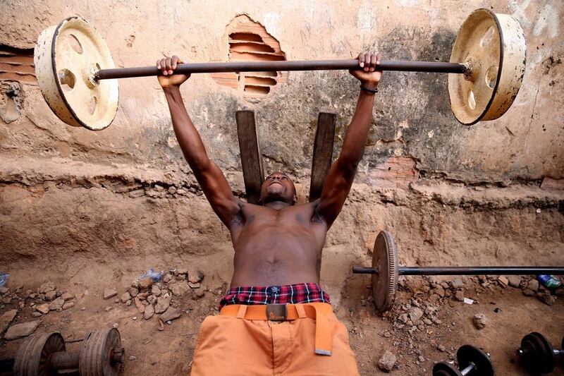 A man training at an open-air gym with rusted rims and other pieces salvaged from workshops or garages, in Bissau, Guinea-Bissau. The gym was founded in 1989 and many of the equipment they use is made from scrap metal. Tiago Petinga / EPA