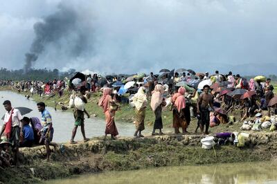 Smoke billows above what is believed to be a burning village in Myanmar's Rakhine state as members of the Rohingya Muslim minority take shelter in a no-man's land between Bangladesh and Myanmar in Ukhia on September 4, 2017.
A total of 87,000 mostly Rohingya refugees have arrived in Bangladesh since violence erupted in neighbouring Myanmar on August 25, the United Nations said Monday, amid growing international criticism of Aung San Suu Kyi. Around 20,000 more were massed on the border waiting to enter, the UN said in a report. / AFP PHOTO / K.M. ASAD