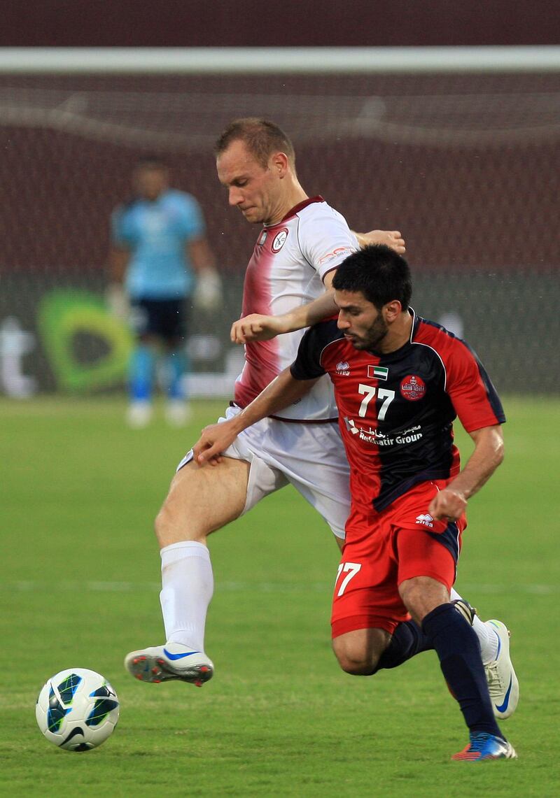 ABU DHABI - UNITED ARAB EMIRATES - 10OCT2012 - AL Wahda's Srdan Andric, in white and Al Shaab's Hassan Maatouk tussels for the ball during Etisalat Cup match yesterday at Al Wahda club in Abu Dhabi. Ravindranath K / The National 