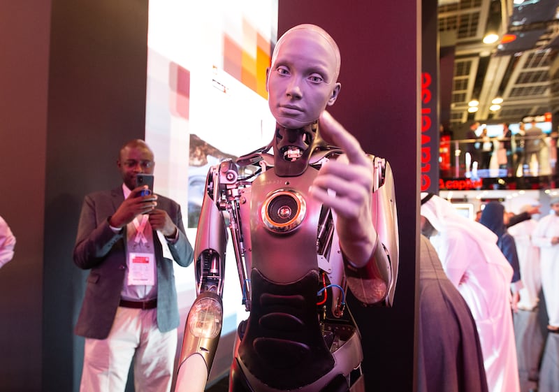 A humanoid robot interacts with visitors at the Etisalat stand.