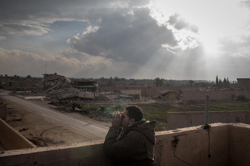 BAGOUZ, SYRIA - FEBRUARY 10:  A Syrian Democratic Forces  (SDF) commander looks for ISIL positions from a rooftop near the front line on February 10, 2019 in Bagouz, Syria.  US-led coalition airstrikes continued across Bagouz as the SDF stepped up their final campaign to oust the remaining ISIL fighters from the  last village held by the extremist group. (Photo by Chris McGrath/Getty Images) ***BESTPIX***