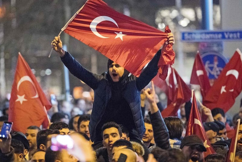 People wave Turkish national flags during a demostration near the Turkish consulate in Rotterdam. Marten van Dijl / AFP Photo


