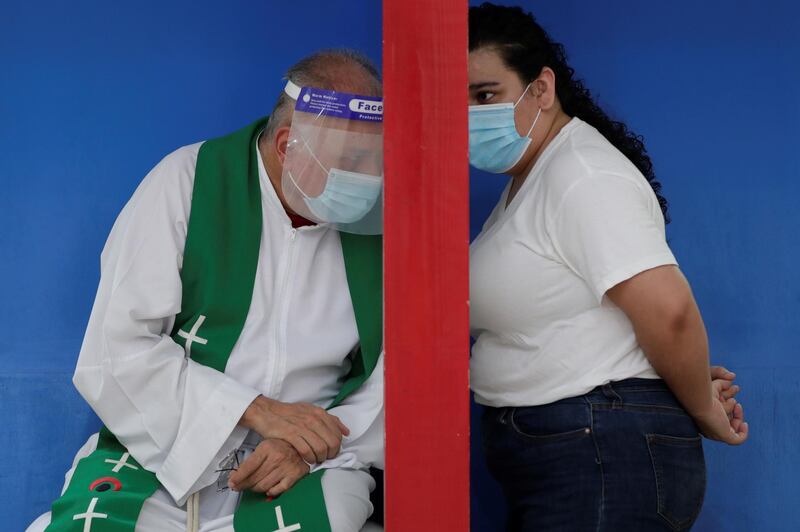 A woman confesses to a priest in the Iglesia del Carmen, in Panama City, Panama. EPA