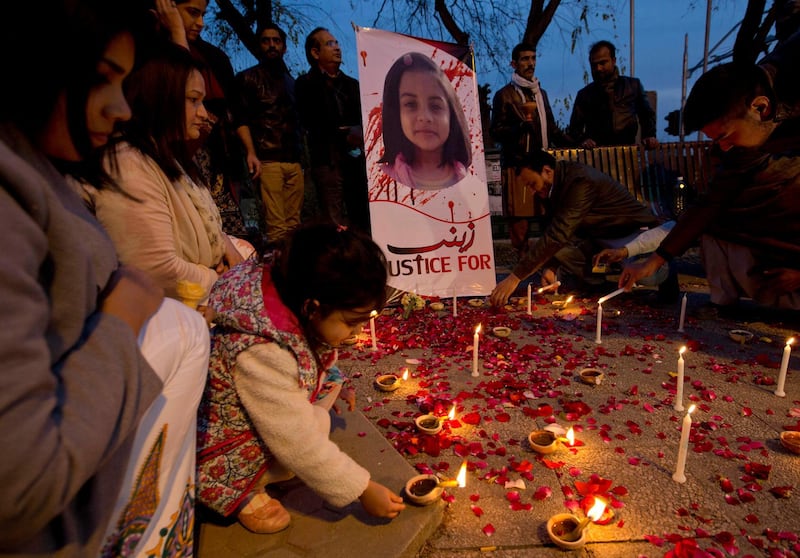 In this Thursday, Jan. 11, 2018 photo, a Pakistani girl lights a candle during a memorial for Zainab Ansari, in Islamabad, Pakistan. The brutal rape of Zainab, whose body was left in a garbage dump earlier this month, has roiled Conservative Pakistan and revealed a sexual predator who has raped and killed at least 11 girls in Zainab's hometown of Kasur. He is still at large. (AP Photo/B.K. Bangash)