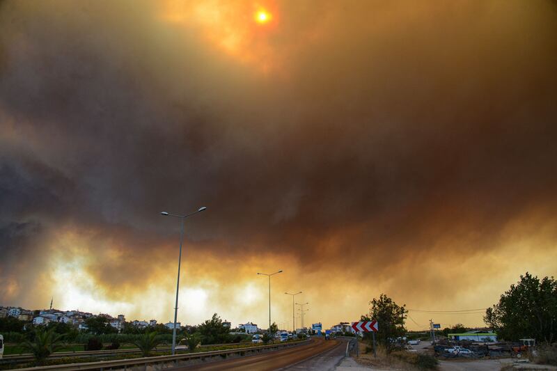 Heavy clouds of smoke rise from a fire that engulfed a Mediterranean resort region on Turkey's southern coast near the town of Manavgat.