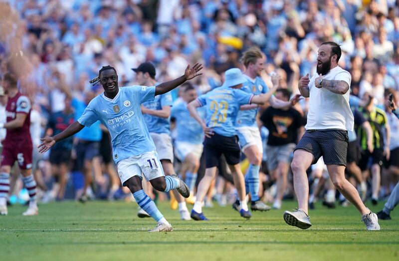 Manchester City's Jeremy Doku celebrates as fans invade the pitch fat the end of the game. PA 