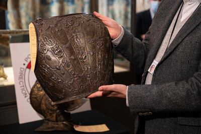 Jean-Luc Martinez, president of the Louvre Museum, holds an ancient breastplate during its official restitution in Paris, on March 3, 2021. A breastplate and a ceremonial helmet, two "exceptional" objects from the Italian Renaissance, were handed over by the police to the Louvre museum after being found in Bordeaux during an auction linked to an estate. These objects, which belonged to the collection of the Baroness de Rothschild, had been donated to the Louvre in 1922 and stolen in 1983. Estimations say they worth around 500,000 euros. / AFP / Thomas SAMSON
