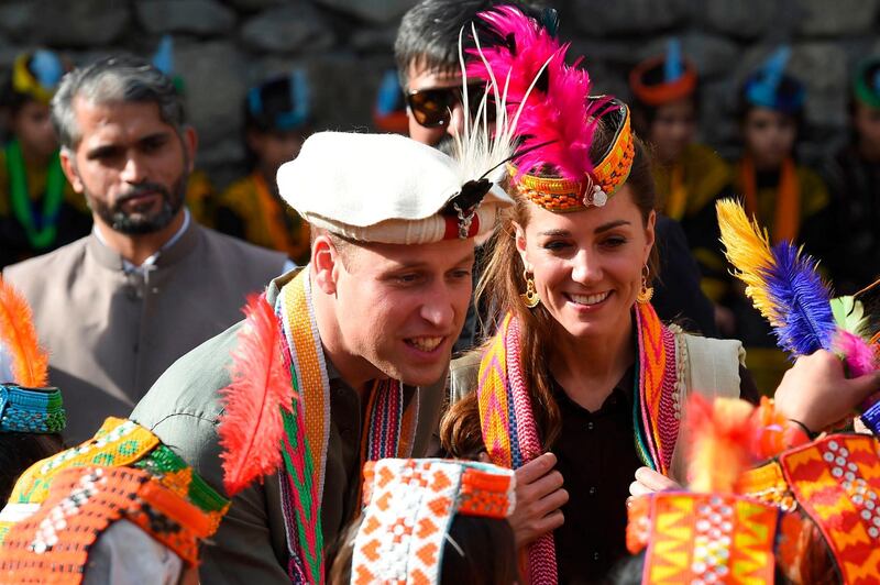 Britain's Prince William (C), Duke of Cambridge and his wife Catherine (R), Duchess of Cambridge, chat with members of the Kalash tribe during their visit to the Bumburate Valley in Pakistan northern Chitral District. Prince William and his wife Kate flew near the Afghan border to visit a remote Hindu Kush glacier, after a morning spent trying on feathered traditional caps and luxurious shawls in Pakistan's mountainous north. AFP