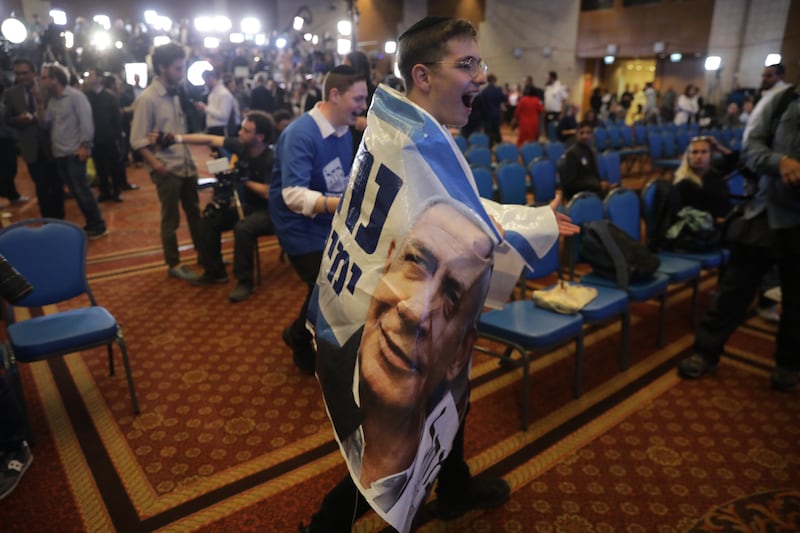 Supporters of Mr Netanyahu react as early exit polls suggest a comeback for the former leader. EPA