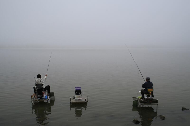 People fish on the banks of the Songhua River on a foggy day in Harbin, Heilongjiang province, China June 22, 2017. REUTERS/Stringer ATTENTION EDITORS - THIS IMAGE WAS PROVIDED BY A THIRD PARTY. CHINA OUT. NO COMMERCIAL OR EDITORIAL SALES IN CHINA.