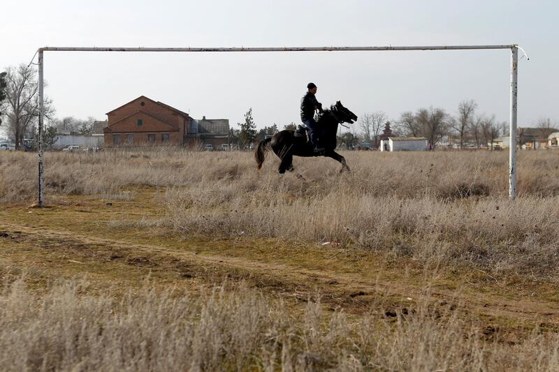 A man rides a horse near a goalpost in the village of Bolshaya Dzhalga in Stavropol region, Russia. Eduard Korniyenko / Reuters