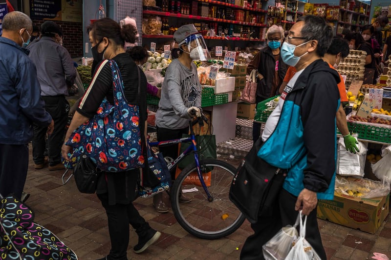People wear masks and face shields as they shop at a food store in Hong Kong. Photo: AFP