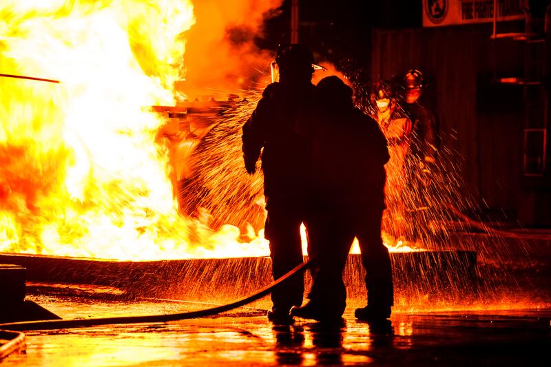 FYPMD7 Firemen using water hose on raging fire