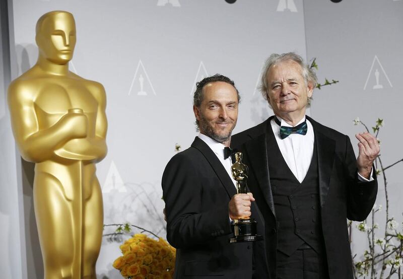 Emmanuel Lubezki poses with his award for best cinematography for his film Gravity with presenter Bill Murray. Reuters