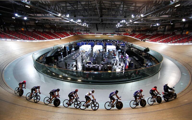 France's national cycling team trains as people get a dose of the  Covid-19 vaccine at the indoor Velodrome National of Saint-Quentin-en-Yvelines in Montigny-le-Bretonneux, southwest of Paris, on Friday, March 26. Reuters