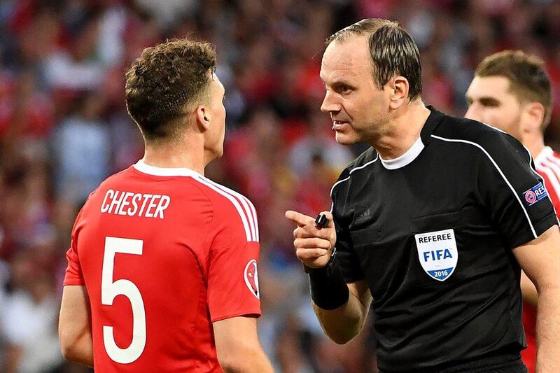 Swedish referee Jonas Eriksson speaks with Wales' defender James Chester during the Euro 2016 group B football match between Russia and Wales at the Stadium Municipal in Toulouse on June 20, 2016. / AFP / PASCAL GUYOT