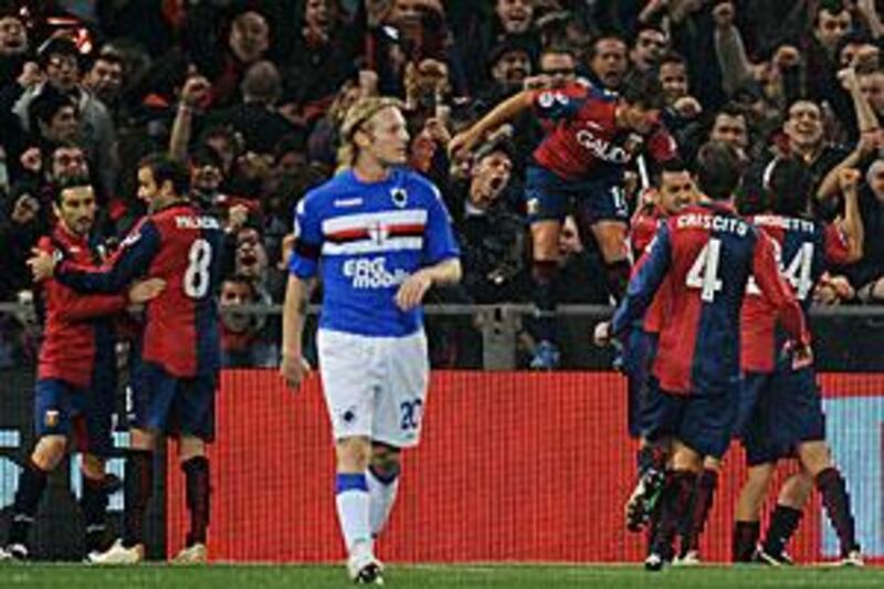 Genoa players celebrate their opening goal in front of their fans as Sampdoria's Marco Padalino, centre, walks away.