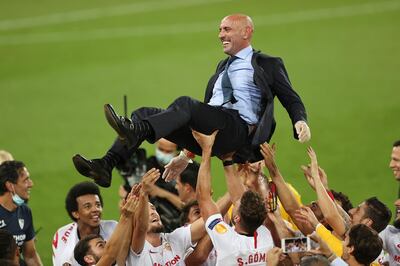 Sevilla's players celebrate with their sport director Monchi, top, after winning the Europa League final soccer match between Sevilla and Inter Milan in Cologne, Germany, Friday, Aug. 21, 2020. (Lars Baron, Pool Photo via AP)