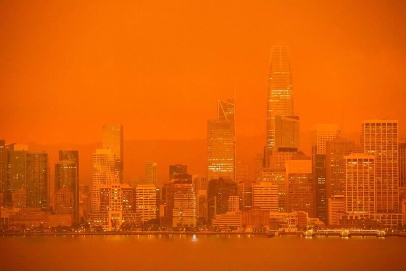 The San Francisco skyline is obscured in orange smoke and haze as their seen from Treasure Island in San Francisco, California.  AFP