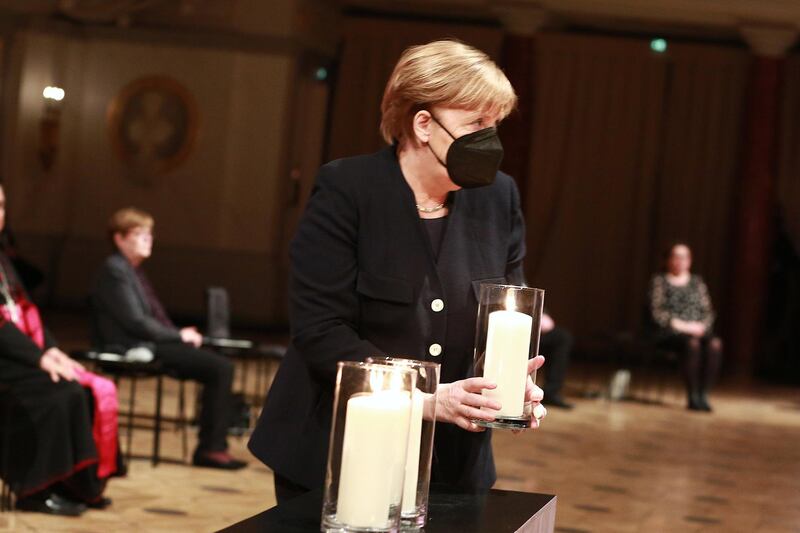 BERLIN, GERMANY - APRIL 18:  German Chancellor Angela Merkel holds a candle during a commemoration ceremony for Germany's coronavirus victims at Gendarmenmarkt concert hall on a national day of mourning on April 18, 2021 in Berlin, Germany. Approximately 80,000 people have died in Germany so far in connection with Covid-19. The country is currently in the midst of a third wave of the pandemic brought on by the spread of the B117 variant. (Photo by Christian Marquar-Pool/Getty Images)