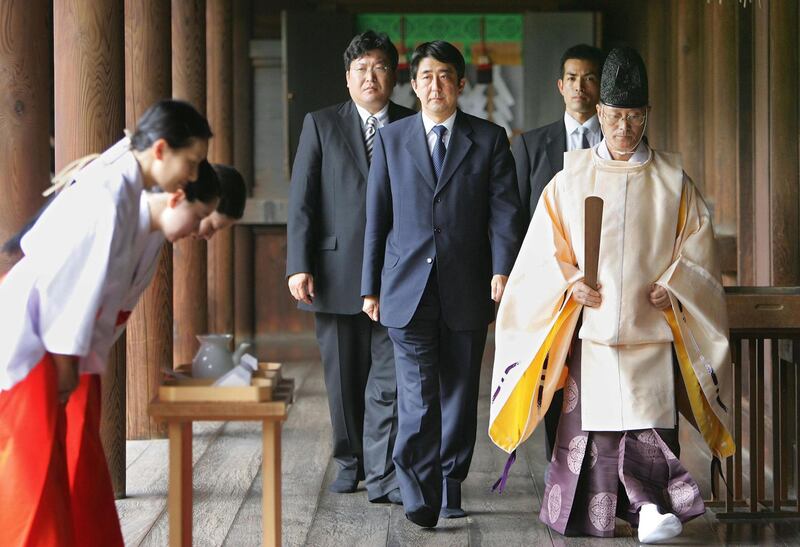 This file photo taken on August 15, 2005 shows Shinzo Abe (C), then-deputy secretary general for Prime Minister Junichiro Koizumi's Liberal Democratic Party (LDP), following a Shinto priest after offering prayers for the country's war dead at Tokyo's controversial Yasukuni Shrine. AFP