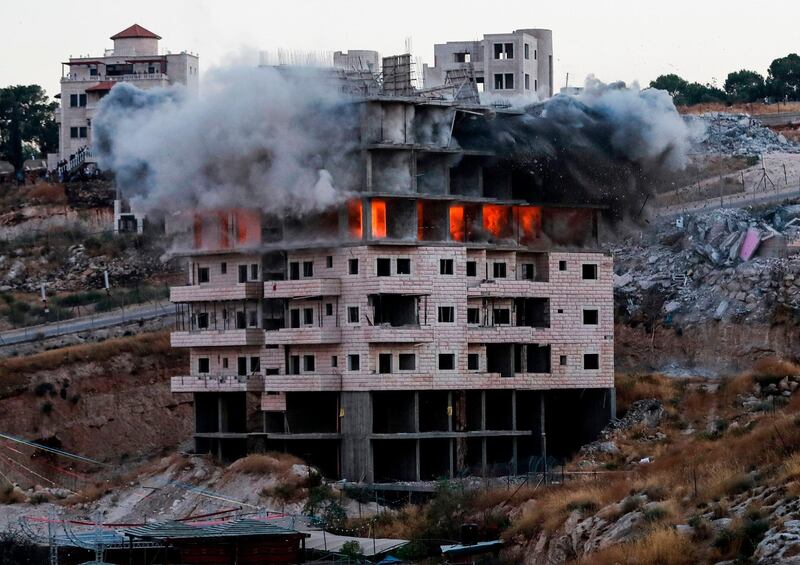 TOPSHOT - This picture taken on July 22, 2019, shows the demolition of a Palestinian building which was under construction, in the the Palestinian village of Sur Baher in East Jerusalem. Israel demolished a number of Palestinian homes it considers illegally constructed near its separation barrier south of Jerusalem on July 22, in a move that drew international condemnation. Palestinian leaders slammed the demolitions in the Sur Baher area which straddles the occupied West Bank and Jerusalem, but Israel defended them as essential to its security and noted they had been approved by its supreme court. / AFP / Ahmad GHARABLI
