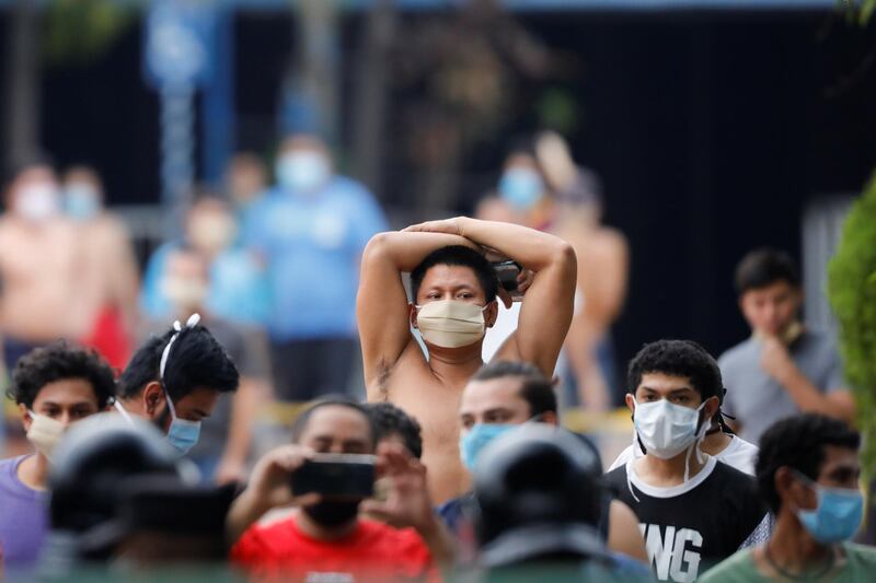 People, who were detained for violating El Salvador's nationwide lockdown measures, protest after authorities did not release them despite having served their mandatory quarantine at a detention center, in San Salvador, El Salvador. Reuters