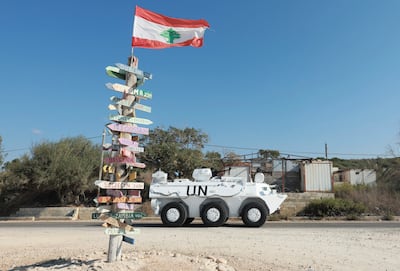 A UN peacekeeper (UNIFIL) vehicle drives near signs bearing the names of cities. Reuters
