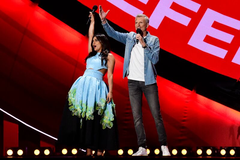 Priyanka Chopra Jonas and Denis Brogniart greet the audience on stage during Global Citizen Live in Paris. Getty Images