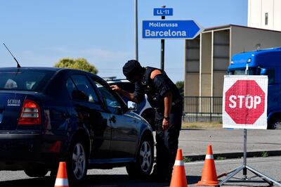 A member of the Catalan regional police force Mossos d'Esquadra controls a checkpoint on the road leading to Lleida on July 4, 2020. Spain's northeastern Catalonia region locked down an area with around 200,000 residents around the town of Lerida following a surge in cases of the new coronavirus. / AFP / Pau BARRENA
