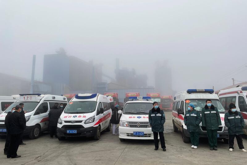 Rescue workers stand next to emergency vehicles outside the Hushan gold mine where workers were trapped underground after the Jan. 10 explosion, in Qixia, Shandong province, China. Reuters