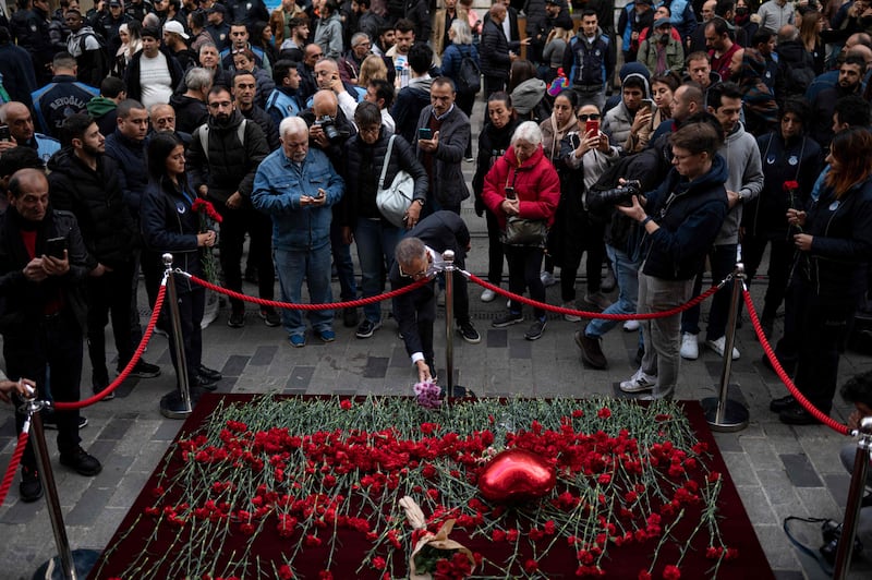 A mourner lays flowers on Istiklal Avenue in Turkey's capital Istanbul, where a bomb blast killed six people on Sunday. AFP