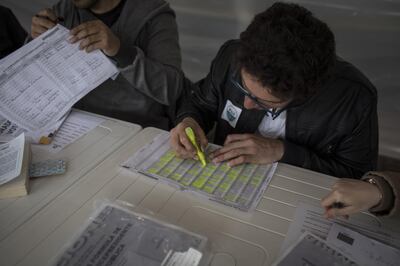 Polling officials verify a voter's identification inside a polling station during presidential elections in Bogota, Colombia, on Sunday, May 27, 2018. Ivan Duque, an investor-friendly lawyer, whose campaign against a peace accord with Marxist guerrillas has divided Colombians, took first place in the country’s presidential election on Sunday. In a June 17 runoff he’ll face former guerrilla Petro, presenting voters with a stark choice. Photographer: Nicolo Filippo Rosso/Bloomberg