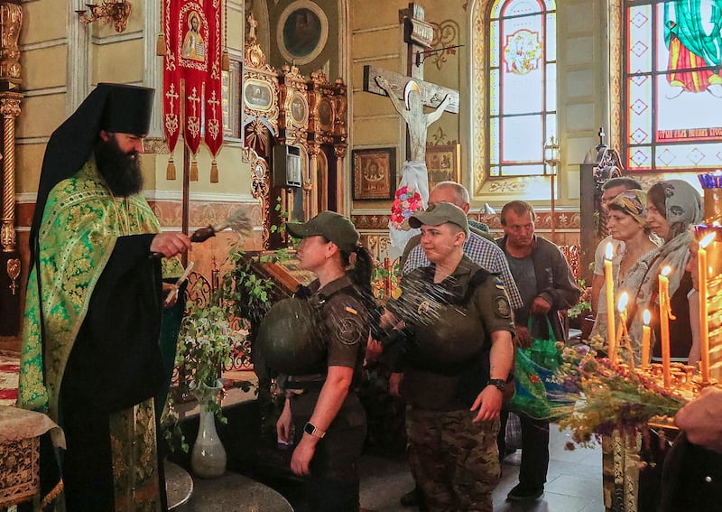 An Orthodox priest blesses Ukrainian soldiers during a service at a church in the Eastern Ukrainian city of Kharkiv. EPA