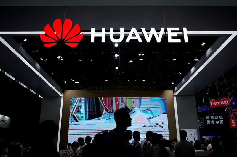 FILE PHOTO: People walk past a sign board of Huawei at CES (Consumer Electronics Show) Asia 2018 in Shanghai, China June 14, 2018. REUTERS/Aly Song/File Photo