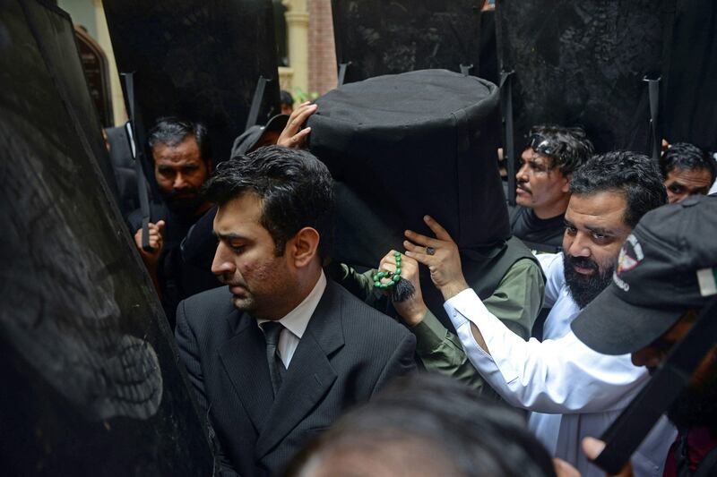 Security personnel with ballistic shields escort former prime minister of Pakistan Imran Khan to the High Court in Lahore. AFP