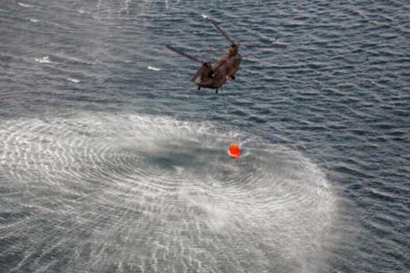 Japan Air Self-Defense Force CH-47 Chinook helicopters collect water from the ocean to drop on the reactors at the Fukushima Daiichi nuclear plant in Fukushima March 17, 2011. Operators of the quake-crippled nuclear plant in Japan again deployed military helicopters on Thursday in a bid to douse overheating reactors, as U.S. officials warned of the rising risk of a catastrophic radiation leak from spent fuel rods.  REUTERS/Yomiuri (JAPAN - Tags: MILITARY DISASTER ENVIRONMENT ENERGY IMAGES OF THE DAY) FOR EDITORIAL USE ONLY. NOT FOR SALE FOR MARKETING OR ADVERTISING CAMPAIGNS. THIS IMAGE HAS BEEN SUPPLIED BY A THIRD PARTY. IT IS DISTRIBUTED, EXACTLY AS RECEIVED BY REUTERS, AS A SERVICE TO CLIENTS. JAPAN OUT. NO COMMERCIAL OR EDITORIAL SALES IN JAPAN. YES *** Local Caption ***  SIN41_JAPAN-QUAKE-_0317_11.JPG