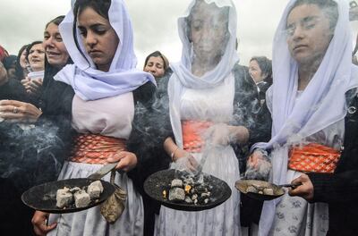 Iraqi Yazidis take part in a ceremony during the exhumation of a mass-grave of hundreds of Yazidis killed by Islamic State (IS) group militants in the northern Iraqi village of Kojo in Sinjar district on March 15, 2019. Iraqi authorities exhumed the mass grave in an operation aiming to extract remains and identify victims of an August 2014 massacre of Yazidis by IS fighters as they entered the village of Kojo, during investigations of genocide against the decimated minority. / AFP / Zaid AL-OBEIDI
