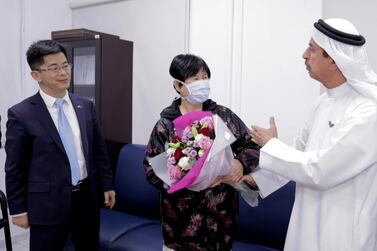 Recovered coronavirus patient Liu Yujia with China’s Consul General Li Xuhang and Dr Hussein Al Rand, assistant undersecretary at the Ministry of Health and Prevention. Wam / AP