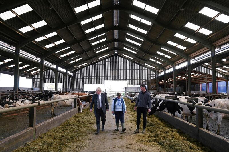 Boris Johnson speaks to Conservative candidate Barbara Hughes while they tour Moreton farm. Reuters