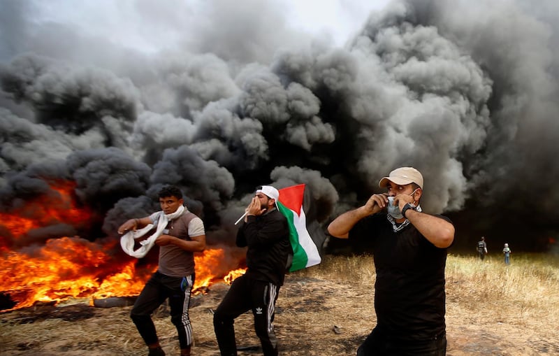 Palestinian protesters chant slogans next to burning tyres east of Khan Younis, Gaza Strip.  Adel Hana / AP Photo