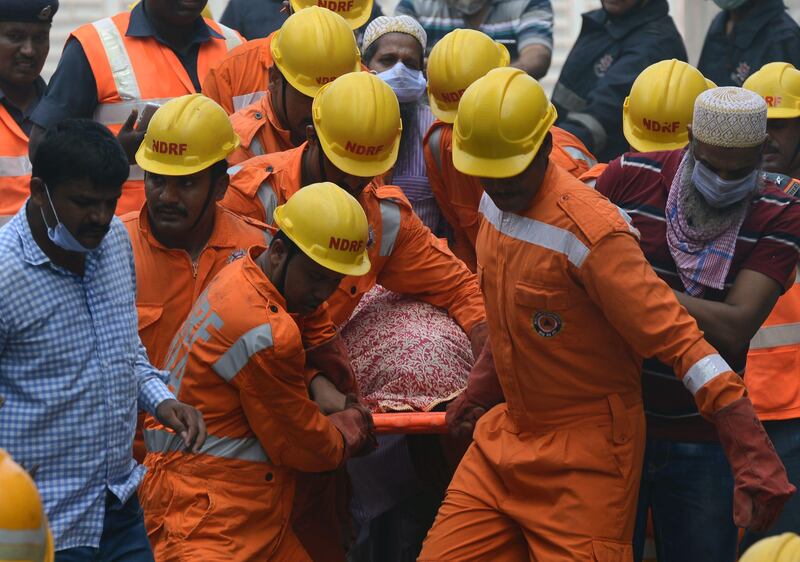 Indian rescue workers carry a victim's body from the building collapse site in Mumbai. Punit Paranjpe / AFP Photo