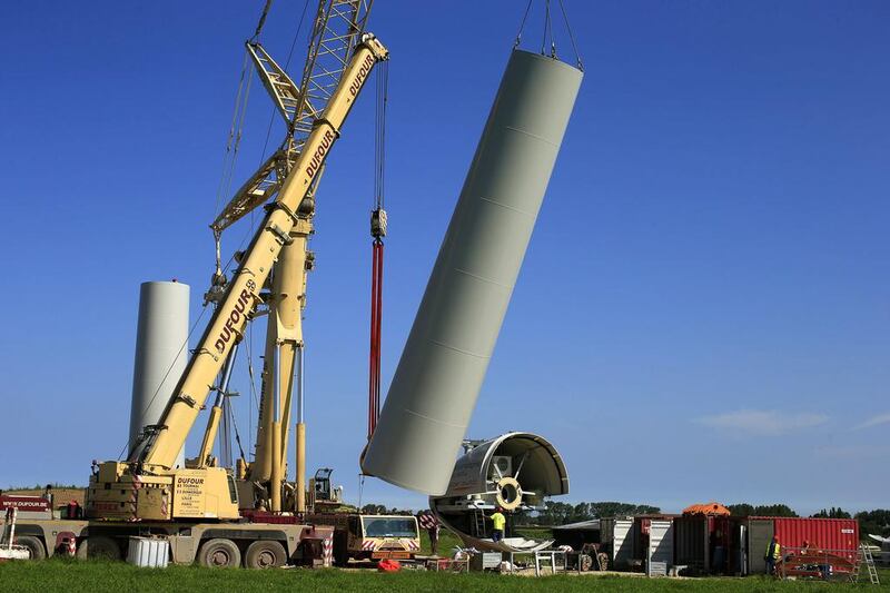 A crane lifts a tower section of an E-70 wind turbine during its installation at a wind farm in Meneslies. France aims to more than double the percentage of renewable energy used in the overall energy scheme to 32 per cent from 12 per cent. Benoit Tessier / Reuters