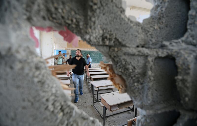 Palestinians inspect a classroom of a United Nations-run school that was damaged in Israeli shelling, in Khan Younis in the southern Gaza Strip September 15, 2018. REUTERS/Ibraheem Abu Mustafa