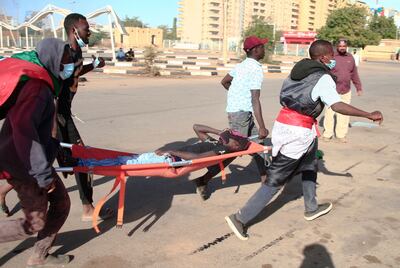 Sudanese protesters carry a wounded youth on a stretcher during  demonstrations against the October 25 coup, in the capital Khartoum, on January 2, 2022.  AFP