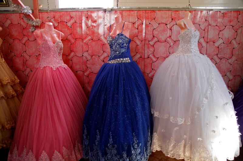 In this Sunday, Aug. 6, 2017  photo, bridal gowns and engagement dresses are displayed in a small shop in the Zaatari camp for Syrian refugees in northern Jordan. A new study based on Jordanian census figures shows that child marriages are up sharply among Syrian refugee girls in the kingdom, and that 44 percent of Syrian females getting married in 2015 were minors. (AP Photo/Reem Saad)