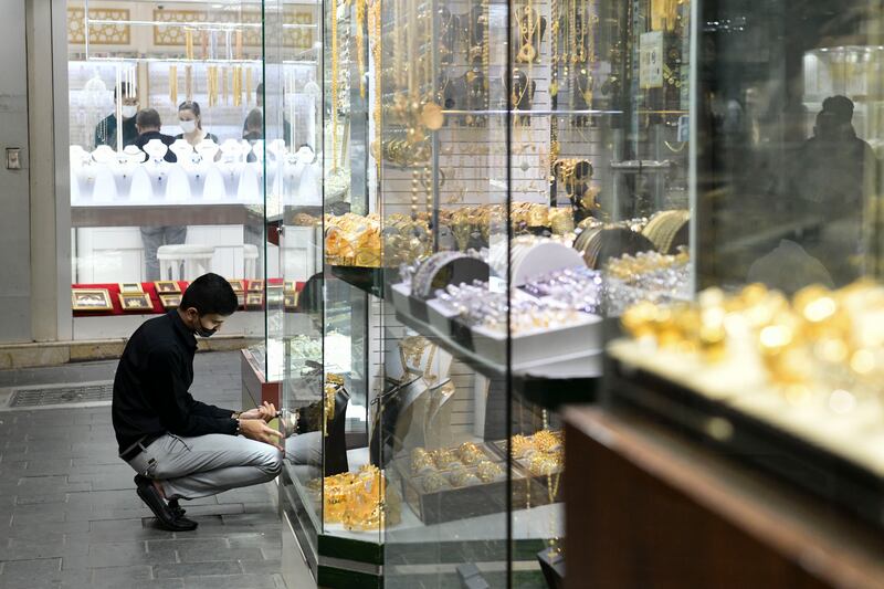 A staff member adds pieces to a window display at the gold souq. It is a popular attraction for visitors to Dubai.
