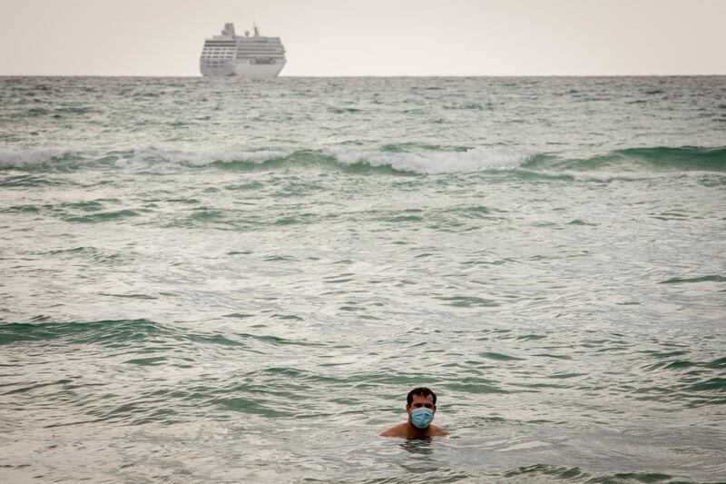 A person wears a protective mask while swimming in the ocean at a beach in Miami Beach, Florida, USA. Bloomberg