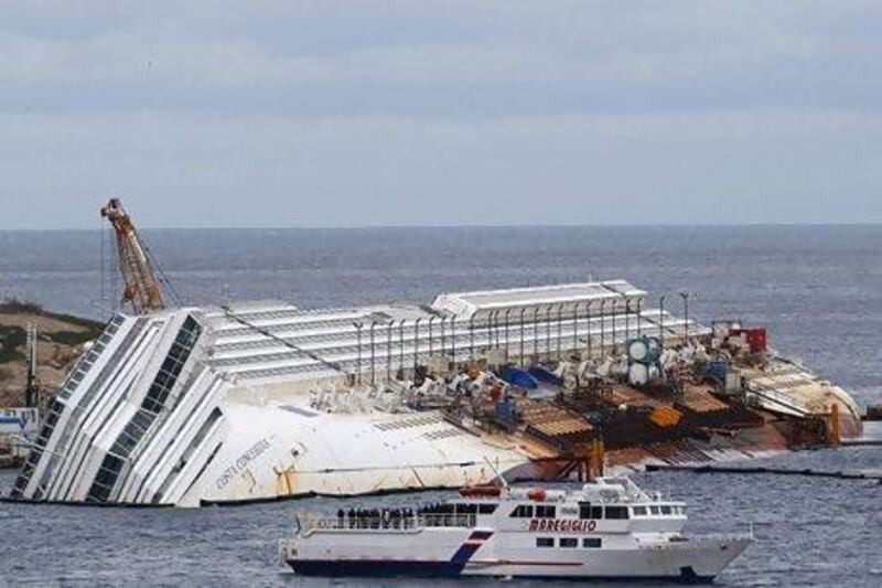 Relatives of victims stand on a ferry in front of the capsized cruise liner Costa Concordia outside Giglio harbour. Stefano Rellandini / Reuters